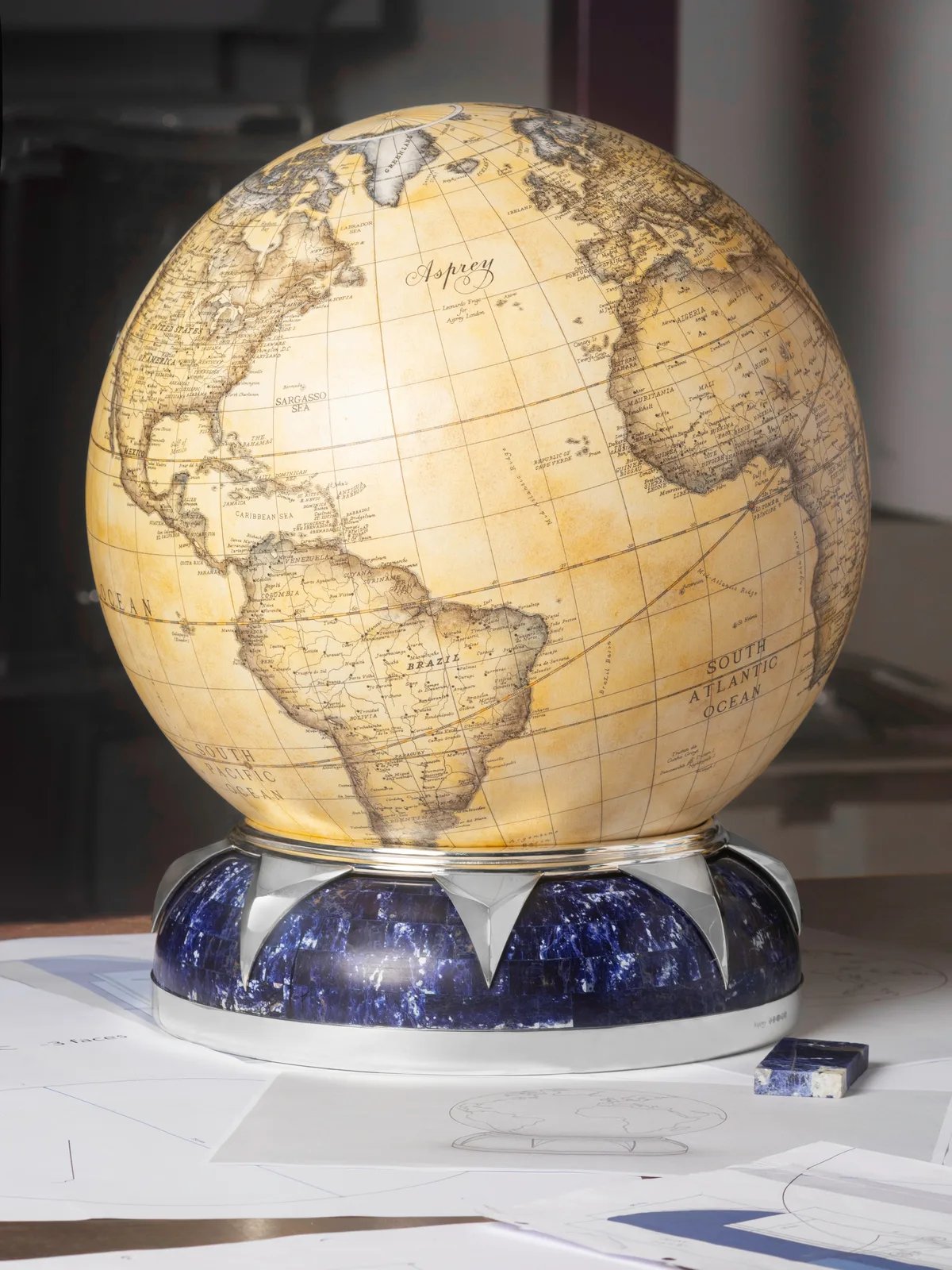 The globe on a silver and blue stone base, among design drawings
