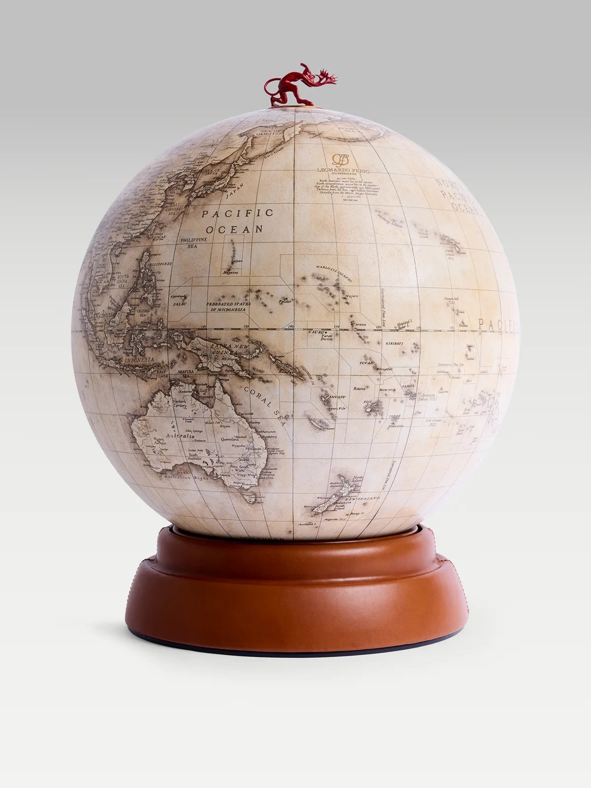 The globe on a tan leather base, with a red figure at its pole