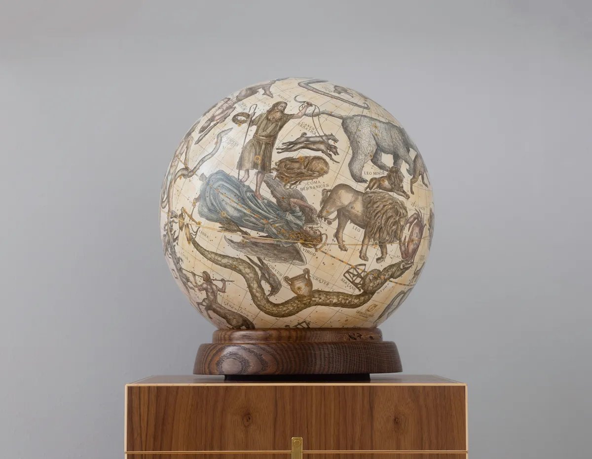 A celestial globe on its turned base, raised on a walnut plinth