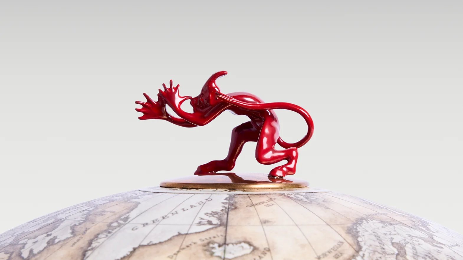 A detail of the red figure mounted on the sphere's brass pole cap