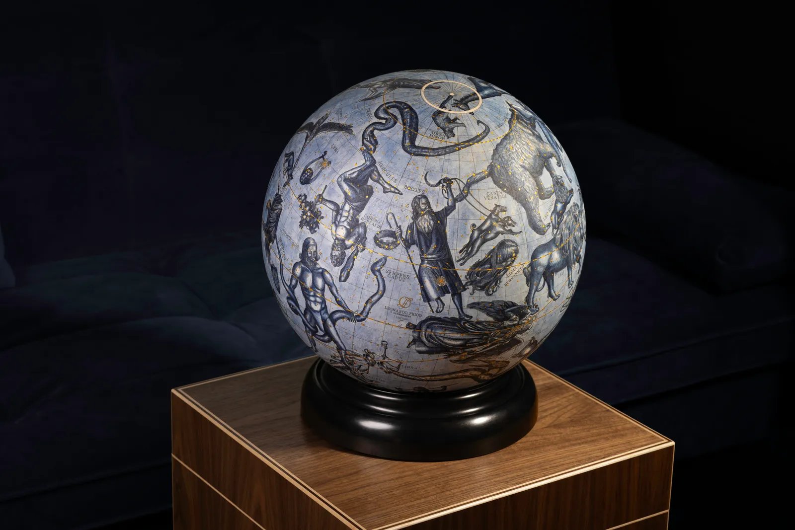 A blue celestial globe on a black turned base, its stars picked out in gold