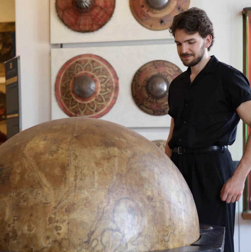 Leonardo Frigo beside a large globe in progress